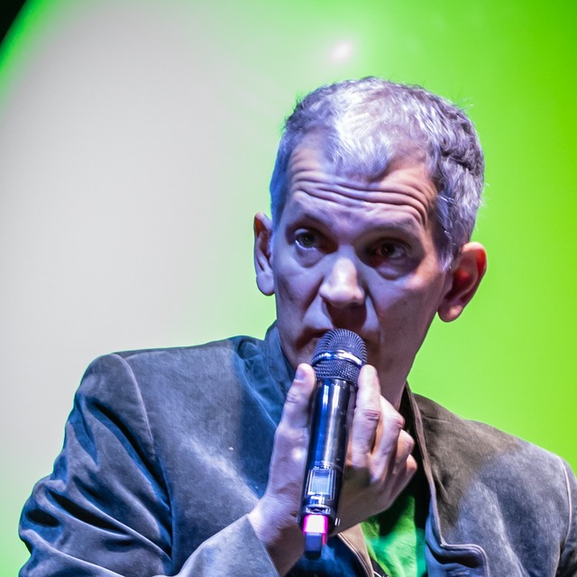Brad Mehldau 在舞台上手持麦克风演唱的近景