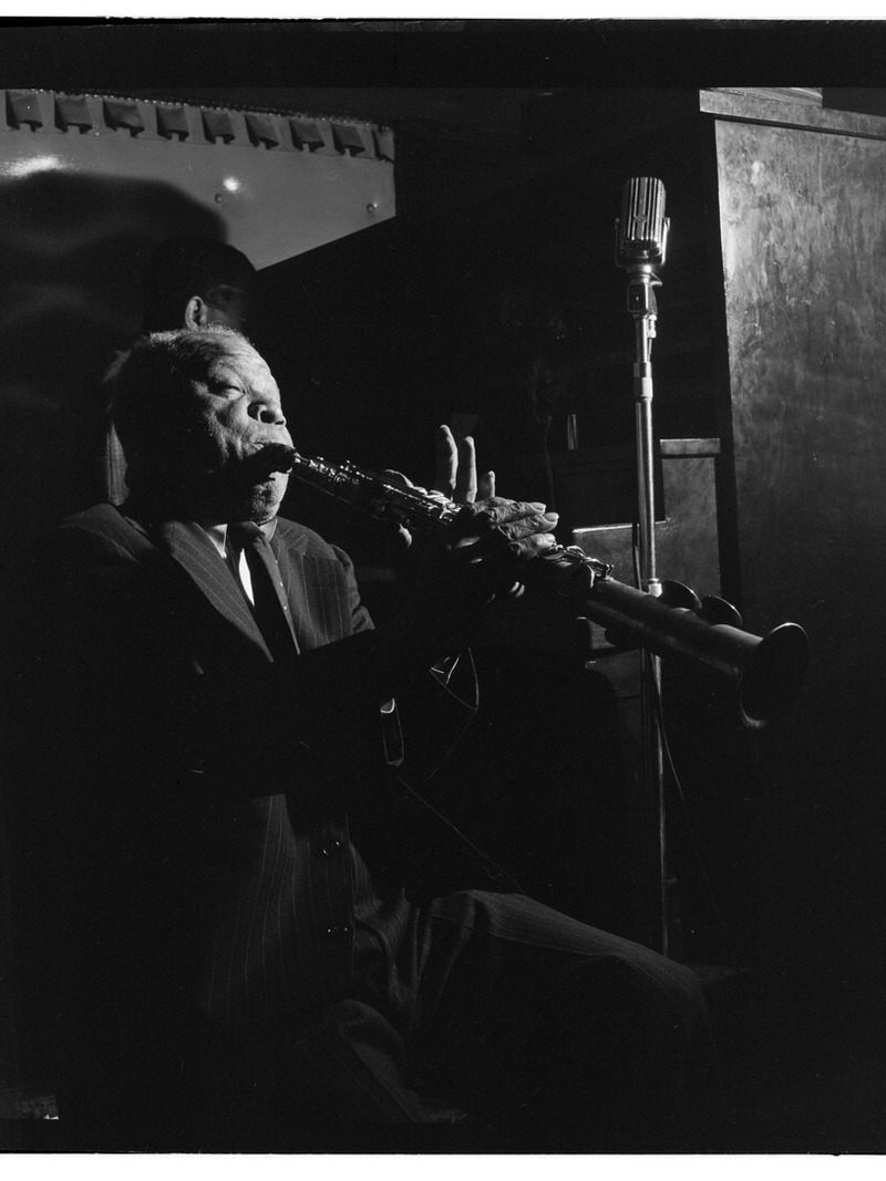 西德尼·贝谢 1947 年 6 月在纽约 Jimmy Ryan's 俱乐部吹奏单簧管，麦克风前侧身演奏